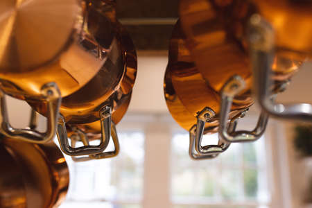 Image of copper pots and plates hanging in kitchen. Home, household and interior design concept.の写真素材