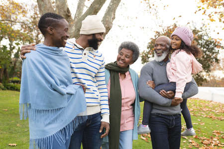 Image of happy multi generation african american family having fun outdoors in autumn. Extended...