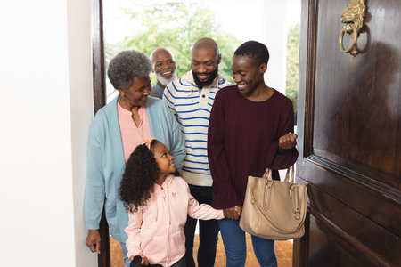 Image of happy multi generation african american family entering house. Extended family, spending...