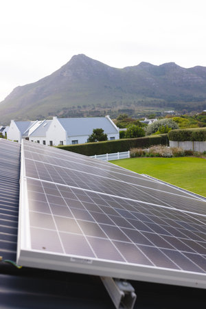 Solar panels on rooftop of house and scenic view of mountain range against clear sky, copy space....