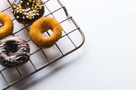 High angle view of fresh donuts on cooling rack by copy space against white background. unaltered,...
