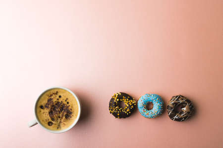 Directly above view of fresh chocolate drink in cup by donuts and copy space over colored background. unaltered, unhealthy eating and sweet food concept.の写真素材