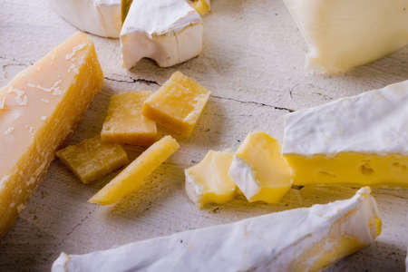 High angle view of various cheese on wooden table, copy space. unaltered, food and dairy product.
