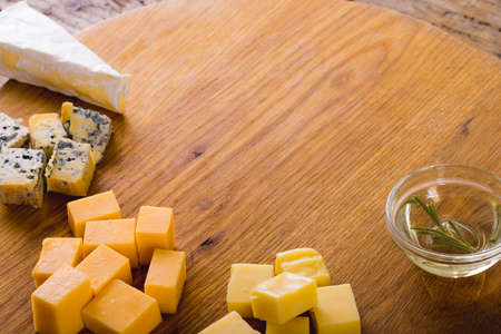High angle view of various cheese with rosemary on wooden board, copy space. unaltered, food and dairy product.の写真素材