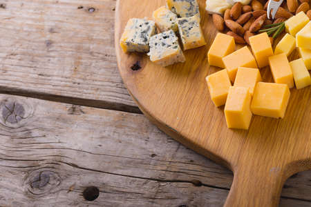 High angle view of various cheese with almonds on wooden board, copy space. unaltered, food and dairy product.の写真素材