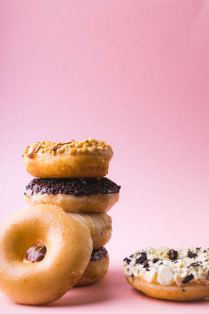 Close-up of fresh donuts stacked against copy space over pink background. unaltered, unhealthy eating and sweet food concept.の写真素材