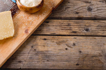 High angle view of cheese and grater on wooden board, copy space. unaltered, food and dairy product.の写真素材