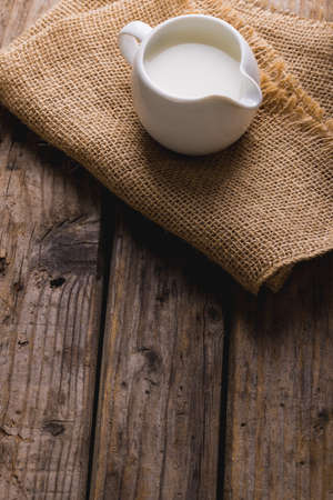 High angle view of milk in jug with burlap on table, copy space. unaltered, food, drink and healthy food concept.の写真素材