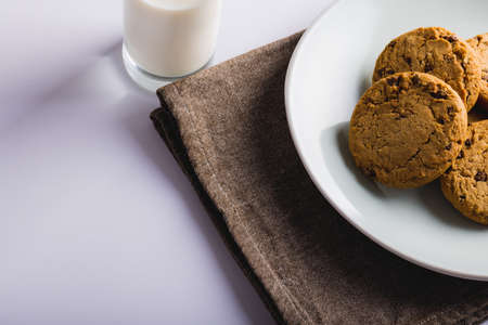 Cookies in plate by milk glass on white background, copy space. unaltered, food, drink, studio shot and healthy food concept.の写真素材
