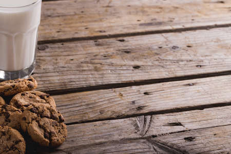Cookies by glass of milk on wooden table with copy space. unaltered, food, drink, healthy eating and snack.の写真素材