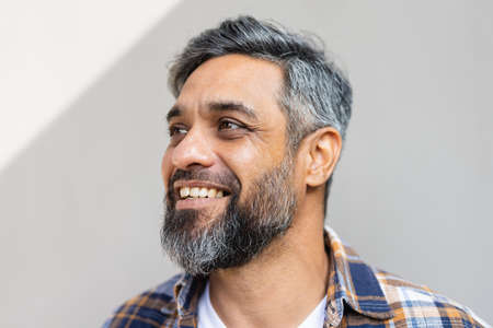 Happy biracial man wearing shirt with white tshirt and smiling. Spending quality time alone at home.