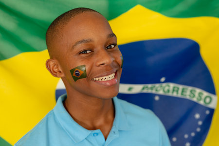 Portrait of happy african american male teenager with flag of brazil. Spending quality time alone at home.の写真素材