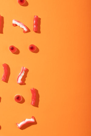 Close up of multiple halloween candies with copy space on orange background. halloween festivity and celebration conceptの写真素材