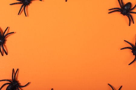 Close up of multiple spider toys with copy space against orange background. fall season and celebration conceptの写真素材