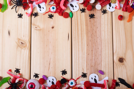 Multiple halloween toys and candies with copy space on wooden surface. halloween festivity and celebration conceptの写真素材