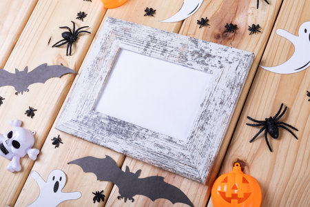 Frame with copy space and multiple halloween toys on wooden surface. halloween festivity and celebration conceptの写真素材