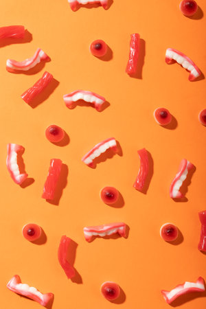 Close up of multiple halloween candies with copy space on orange background. halloween festivity and celebration conceptの写真素材