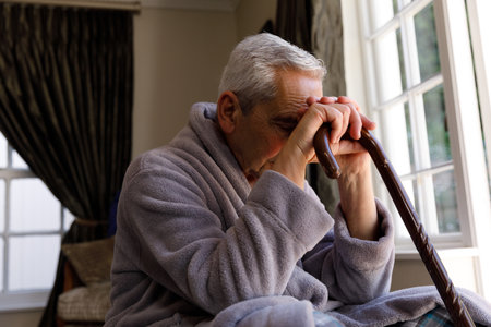 Senior caucasian man spending time at home, leaning on walking cane. isolating during virus quarantine lockdown.の写真素材