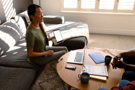 African american senior couple meeting with asian financial advisor holding tablet with copy space....