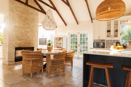 General view of modern kitchen with table, chairs, countertop and fireplace. House interior and design concept.の写真素材