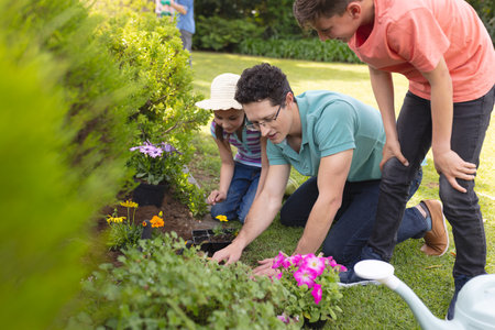 Caucasian family spending time together in the garden, planting. Family time spending outside ,...