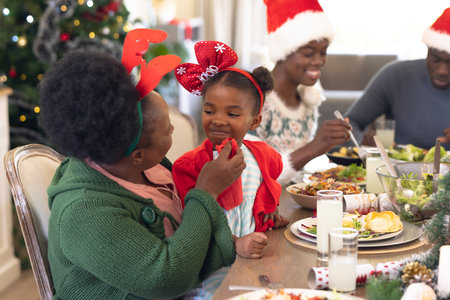African american family spending time together at the table having a christmas meal. Christmas, family time and celebration concept.の写真素材