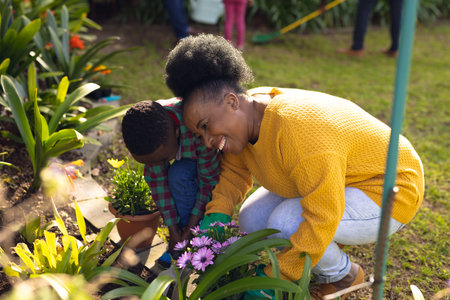 African american mother and son spending time together in the garden and gardening. Family time, garden, gardening.の写真素材