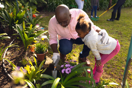 African american father and daughter spending time together in the garden and gardening. Family time, garden, gardening.の写真素材
