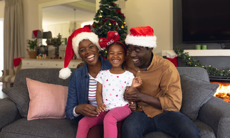 Happy african american family spending time together siting on the sofa. Christmas, family time and celebration concept.の写真素材