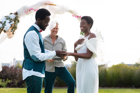 Happy african american couple holding hands during wedding. Wedding day, friendship, inclusivity and...