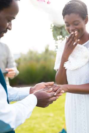 Happy african american couple holding hands during wedding. Wedding day, friendship, inclusivity and lifestyle concept.の写真素材
