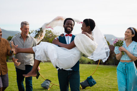 Portrait of happy african american couple carrying during wedding. Wedding day, friendship,...