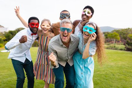 Portrait of happy african american couple with diverse friends embracing during wedding. Wedding day, friendship, inclusivity and lifestyle concept.の写真素材