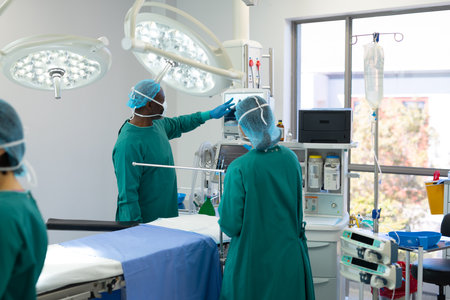 Diverse group of surgeons ready for surgery checking equipment in operating theatre before operation. Hospital, medical and healthcare services.の写真素材
