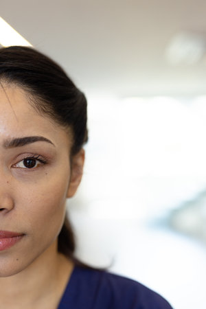Vertical half face portrait of biracial female healthcare worker, with copy space. Hospital, medical...