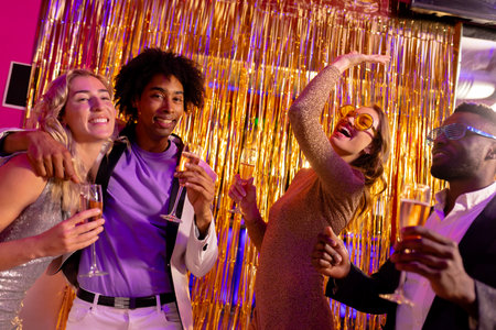 Two happy, diverse couples dancing and drinking champagne at a nightclub. Fun, drinking, going out,...