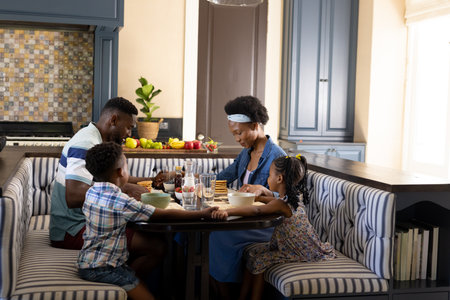 African american parents and children having fresh breakfast at dining table in morning, copy space. Unaltered, family, togetherness, childhood, food and home concept.の写真素材