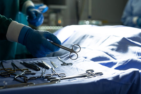 Hands of surgical tech picking up instrument for surgeon in operating theatre, with copy space. Hospital, medical and healthcare services.の写真素材