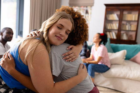 Supportive diverse female friends hugging each other at group therapy session. Therapy, mental health, friendship and support, unaltered.の写真素材