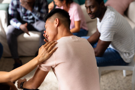 Supportive diverse friends crying and comforting each other in group therapy session. Therapy,...