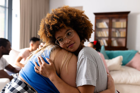 Supportive diverse female friends hugging each other at group therapy session. Therapy, mental health, friendship and support, unaltered.の写真素材