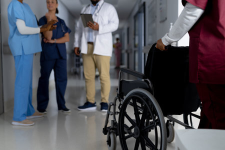 African american female doctor walking with wheelchair in corridor at hospital. Hospital, medicine,...
