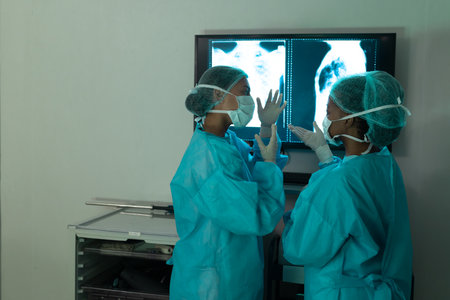 Diverse female surgeons looking at x-ray scans in operating theatre at hospital. Hospital, surgery,...