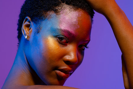 African american woman with short hair and colourful make up touching head. Femininity, face, facial...