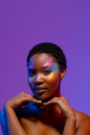 African american woman with short hair, colourful make up and hands under chin, copy space. Femininity, face, facial expressions, body, skin, makeup, fashion and beauty, unaltered.の写真素材