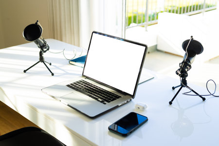 Smartphone, laptop with copy space on screen and microphone on desk at home. Communication, technology, social media and domestic life.の写真素材