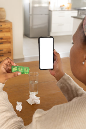 African american woman using smartphone with copy space for online consultation with doctor....