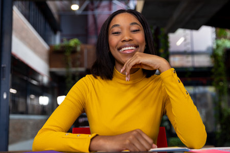 Portrait of a african american businesswoman smiling on a video call at office. Casual business,...