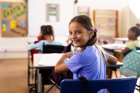 Portrait of happy caucasian schoolgirl in diverse elementary school class. School, learning, childhood, teaching and education, unaltered.の写真素材