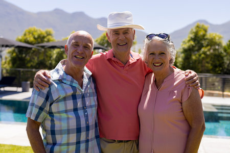 Portrait of happy senior diverse people embracing and smiling in garden. Senior lifestyle, friendship and relaxation, summer, retirement, unaltered.の写真素材